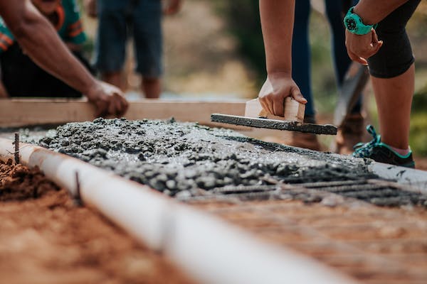 closeup photo of wet concrete being smoothed for pavement